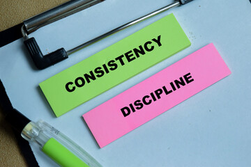 Obraz premium Concept of consistency discipline write on sticky notes isolated on Wooden Table. For essential building blocks of success and growth