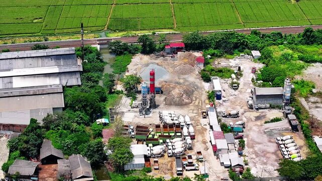 Aerial view of a concrete batching plant with cement mixer trucks parked