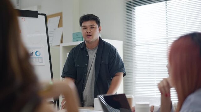 Group of Asian businesspeople work together leads business meeting,brainstorming uses presentation at office.business team generation z brainstorm planning and strategy new product project in office
