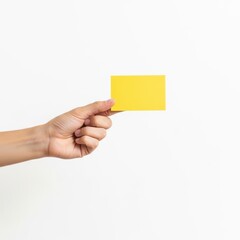 Fototapeta premium A hand holding a bright yellow sticky note against a plain background