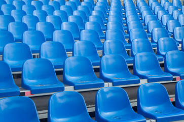 Naklejka premium Empty blue plastic seats in symmetrical rows , abstract repeating pattern