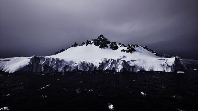 Frozen flat meets deep waters. Cold snowfield blends with shadowed ocean seen afar. Chilled icy area beneath thick mist merges into dark sea view