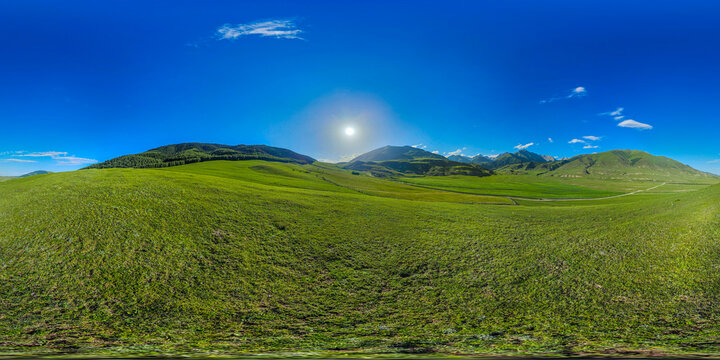 Full 360 degree equirectangular panorama of vast rolling green hills and majestic mountains in Kyrgyzstan bathed in warm sunlight.
