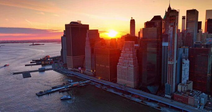 Bright setting sun over the cluster of high-rises. Sundown in gorgeous New York City, USA from drone flying over the East River.