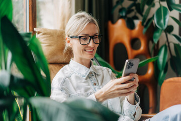 Happy smiling blonde woman using a mobile phone.
