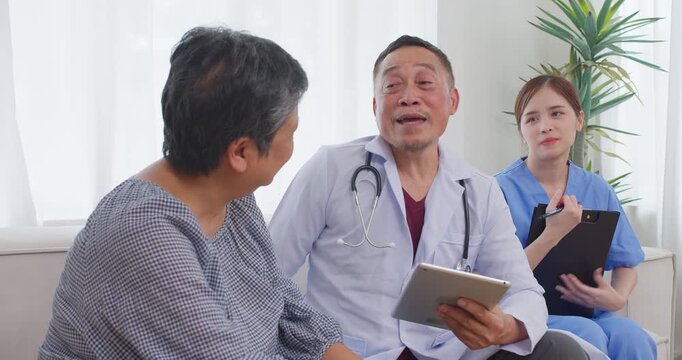 Senior doctor happily sharing results on a digital tablet in a comfortable home setting, focusing on compassionate senior care, positive health outcomes, and accessible medical services.