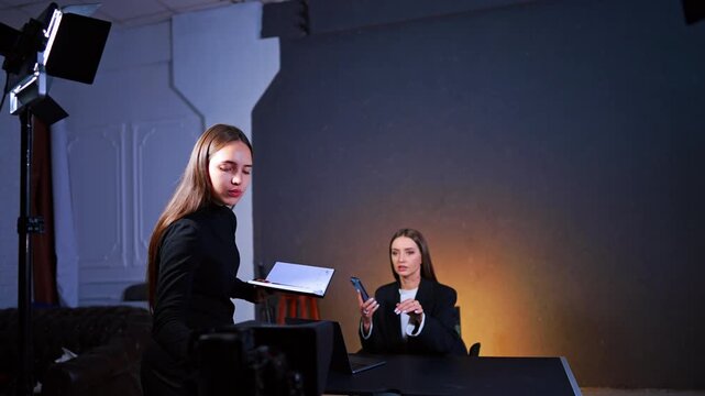 Two women are in photo studio. Preparation for the blog footage. Checking the equipment before filming.