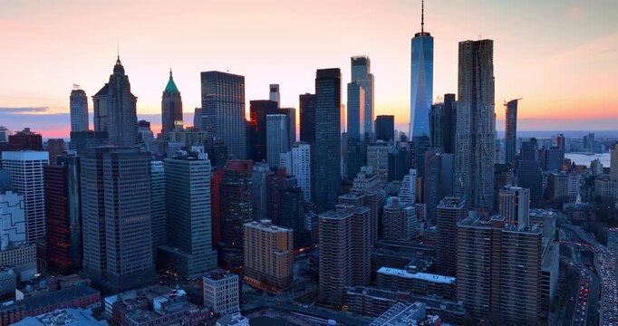 Skyscrapers skyline against the sky lit by the setting sun. Footage over the cityscape of Manhattan, New York City, USA at sundown.