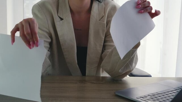 A girl tears up a paper contract to terminate a partnership.
An angry girl destroys a signed contract.
Destruction of important documents