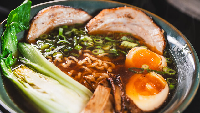 Creative homemade ramen using instant noodles combined with tender chashu pork belly, soft boiled egg, fresh bok choy, bamboo shoots and scallions in a rich pork broth with soy umami flavor. Fusion of