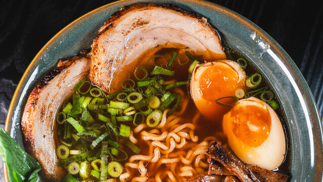 Creative homemade ramen using instant noodles combined with tender chashu pork belly, soft boiled egg, fresh bok choy, bamboo shoots and scallions in a rich pork broth with soy umami flavor. Fusion of