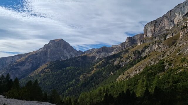 The winding Vallunga hiking trail among the rocks with a mountain refuge in the Puez Geisler nature park in Selva. Panorama.