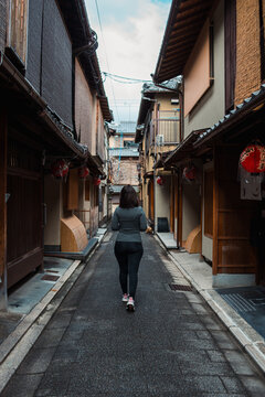 Woman walking through a traditional narrow street in Kyoto, Japan