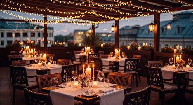 Elegant outdoor dining area illuminated by string lights and numerous candles at dusk