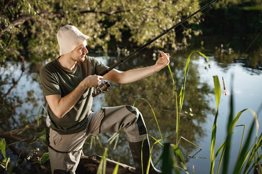 Young fisherman with fishing rod near the lake at summer