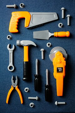 Vertical top view of children's plastic tool set on denim background.