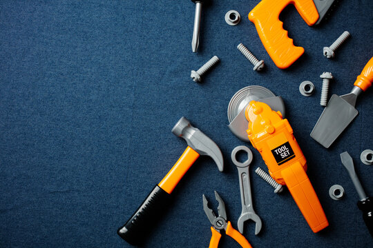 Kids toy tools on denim background with copy space on the left side.