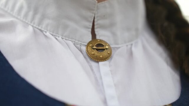 Traditional Latvian dress collar detail with decorative button showcasing intricate design and fabric texture in close-up view