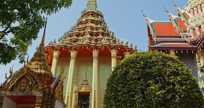 Thailand, Bangkok, Toutists are walking in park near the Beautiful Golden Temple of the Emerald Buddha Wat Phra Kaew at sunny day