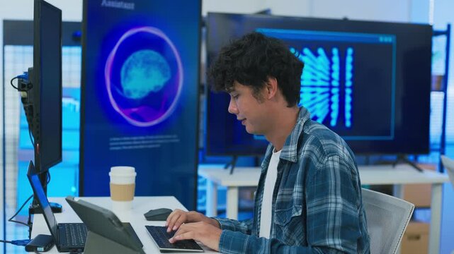 focused young male developer with curly hair in blue plaid shirt intensely codes on laptop in modern AI office, surrounded by multiple monitors displaying code neural networks and data graphs	