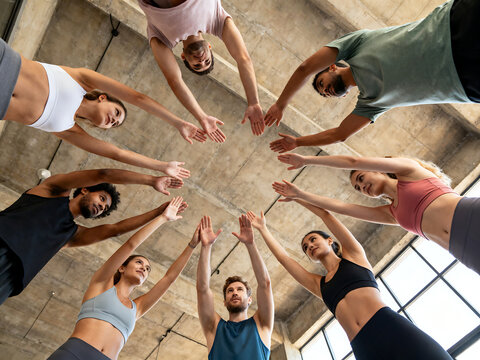 Diverse fitness group in circle high five, low angle view of athletic people celebrating workout, motivated gym team unity and community spirit isolated on White Background