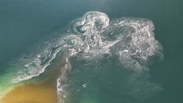 Abstract aerial view of brown water flowing into blue water, natural contrast and mixing