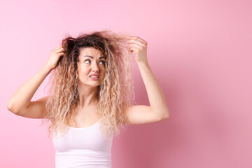 Fototapeta premium Unhappy woman with tangled hair on pink background, space for text