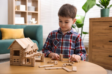 Little boy playing with educational toy at wooden table indoors © New Africa