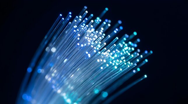 Close-up of glowing blue fiber optic cables on dark background
