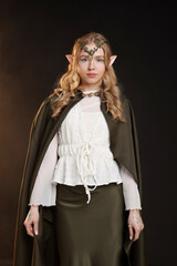 Obraz premium Beautiful girl dressed as elf on dark background
