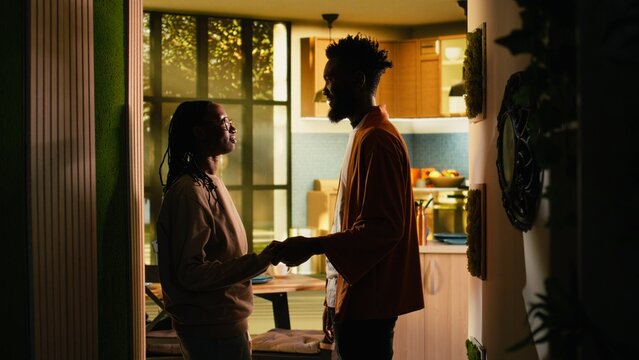 Loving black couple holding hands after fight, enjoying calm reconciliation moment indoors. Man and woman show forgiveness, bonding and emotional connection, healthy relationship unity.