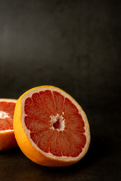 Grapefruit cut in half on a dark surface 