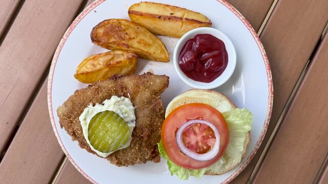 Rotating Plate with a Fried Fish Sandwich and French Fries