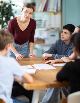 Teen gathering to round table talks to carrying out discussing, chatting, disputing under woman coach guidance. Acting masters courses, co-education, group practice of public speaking