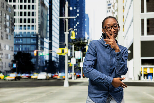 Woman performs stylish street dance movements on city street. African american young girl participating in flash mob, executing choreographed routine in metropolitan area avenue
