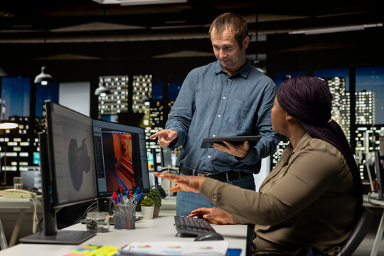 Coworkers using AI chatbot interface to generate video game spaceship environments, modern system applies deep learning and machine learning techniques. Developing sci fi gaming designs.