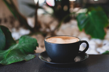 Fototapeta premium Minimalist Coffee Composition with Stones and Leaf. Coffee in Black Cup with White Pebbles and Leaf. Minimal Zen Style Coffee Setup with Natural Elements. 