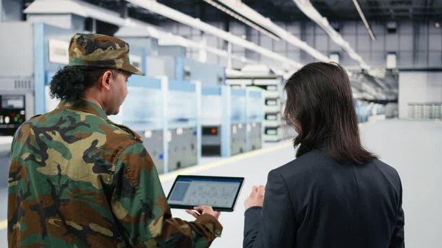 Microelectronics factory technician and soldier analyze EDA software schematics to increase microchips production. Government looking to upgrade national semiconductors manufacturing efforts, camera A