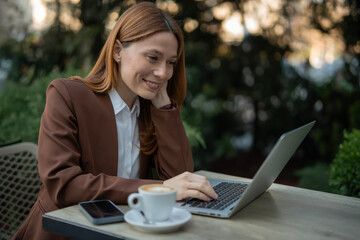 Professional woman working remotely on laptop outdoors