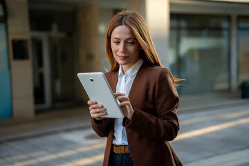 Professional woman managing tasks using digital tablet outdoors