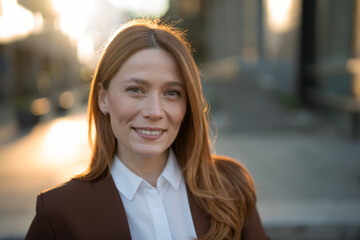 Smiling young businesswoman posing with confidence in city