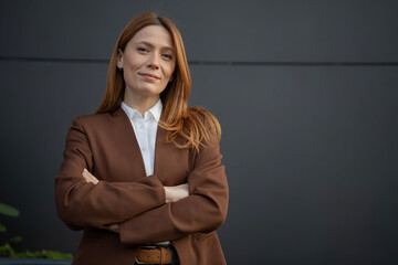 Confident businesswoman smiling with arms crossed looking