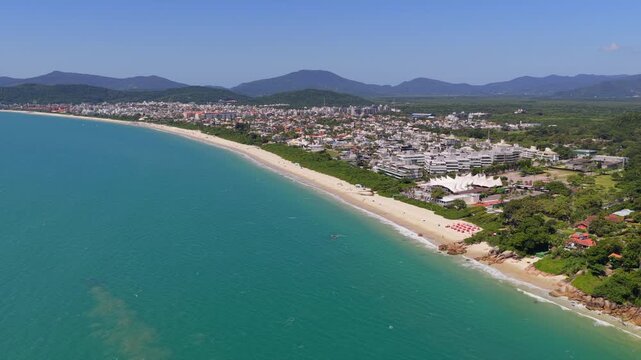 Sweeping coastal panorama of Jurere Internacional shoreline with lush vegetation, Florianopolis.