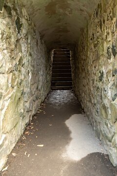 Narrow Stone Passage With Dark Staircase