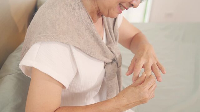Asian senior woman suffering from finger joint pain, elderly female with hand arthritis and rheumatoid condition, trigger finger and stiffness problem, healthcare aging and chronic joint disorder