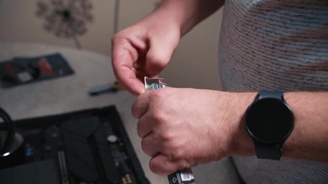 Opening thermal paste box before processor installation, careful removal of thermal paste tube by hands on a work desk during personal computer assembly preparation
