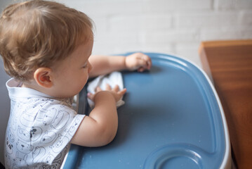 Fototapeta premium baby wiping the table after eating