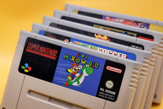 OURENSE, SPAIN - APRIL 5, 2026: Close-up of Super Nintendo Entertainment System (SNES) game cartridges including Super Mario titles, classic 1990s gaming media on yellow background.