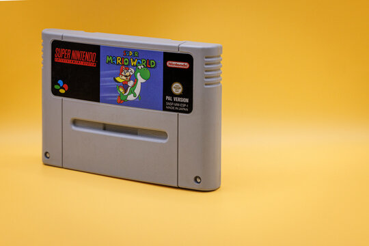 OURENSE, SPAIN - APRIL 5, 2026: Super Mario World game cartridge close-up, classic 1990s gaming media on yellow background