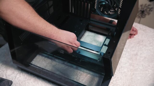 Installing motherboard standoffs inside computer case, screwing mounting standoffs into the computer case before motherboard installation